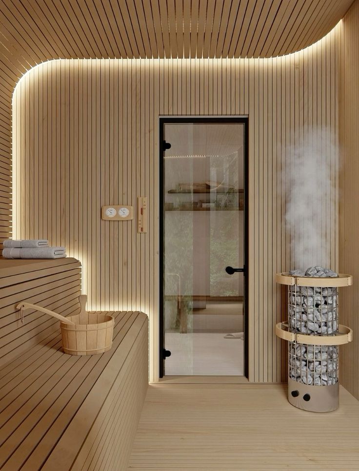 Loyly steam rising off the heater in a light-toned cedar sauna with a glass door