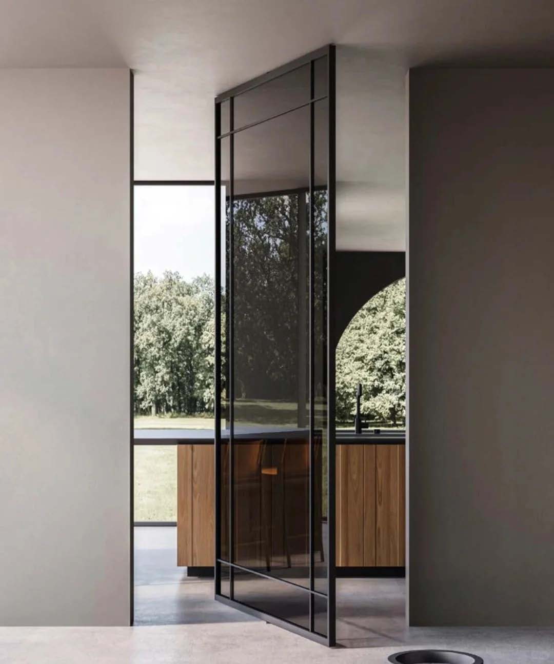 Tall interior aluminum pivot door turning on a floor pivot between living spaces.